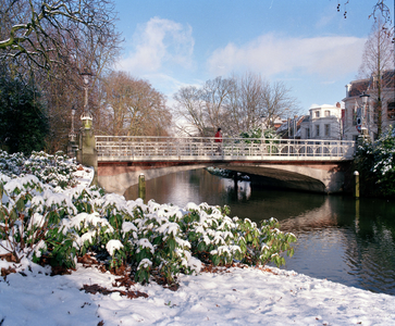 842161 Gezicht op de besneeuwde Herenbrug over de Stadsbuitengracht te Utrecht, met rechts panden aan de Maliesingel.